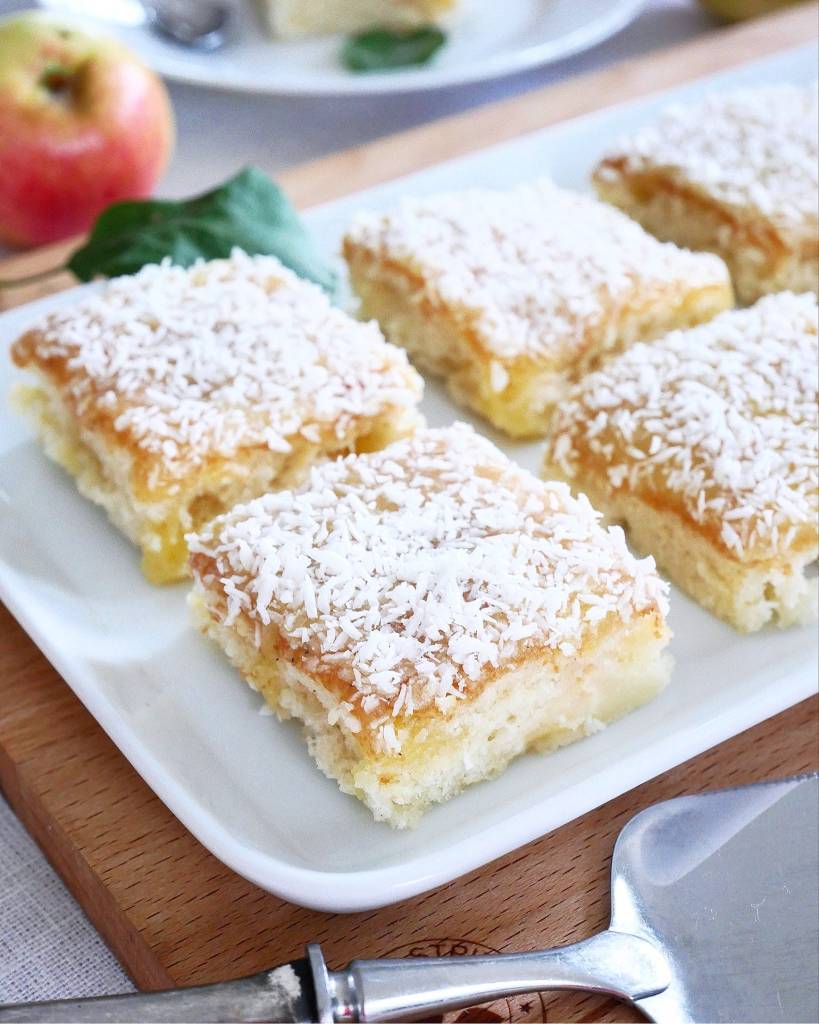 Äppelpaj för två 12 Fyra bitar av silviakaka med äpple och kokos på en vit tallrik.