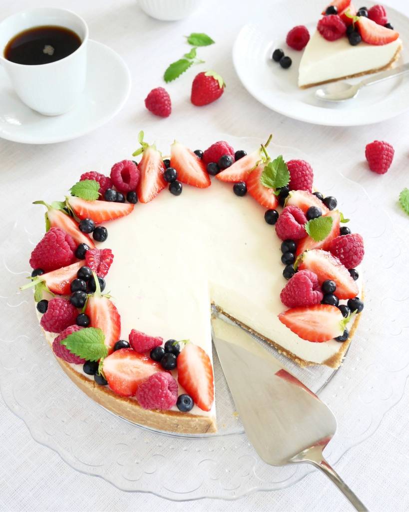 Jordgubbstårta med citron 13 Cheesecake dekorerad med jordgubbar, hallon, blåbär och mynta på en glasskiva.