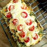 Överbakad torskrygg med tomater och grönsaksbädd i en ugnsform.