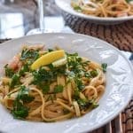 Tallrik med pasta, fisk och skaldjur, toppad med citron och färsk persilja.