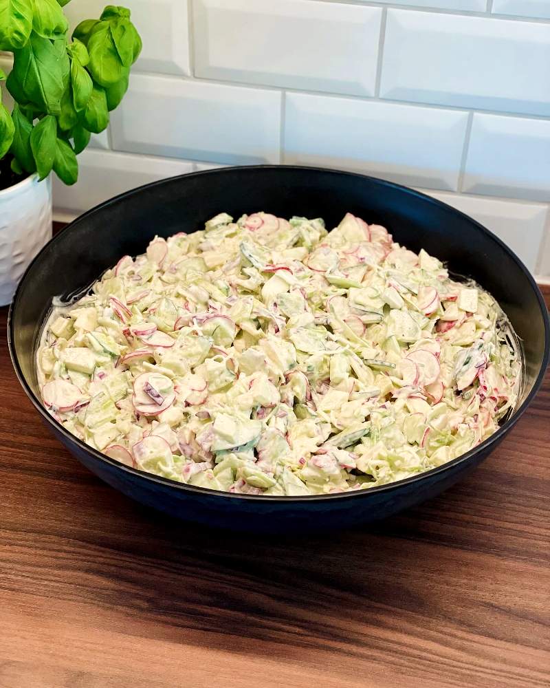 Pastasallad med kyckling 9 Kramig grillsallad med grönsaker och dressing i en svart skål.
