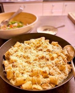 Pasta med kyckling, vitlök, citron och parmesan i en svart skål.