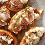 Mackor med nduja, fikon, och hackade nötter på en tallrik.