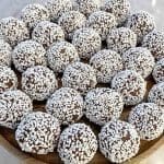 Runda chokladbollar täckta med kokos och pärlsocker på en träskål.