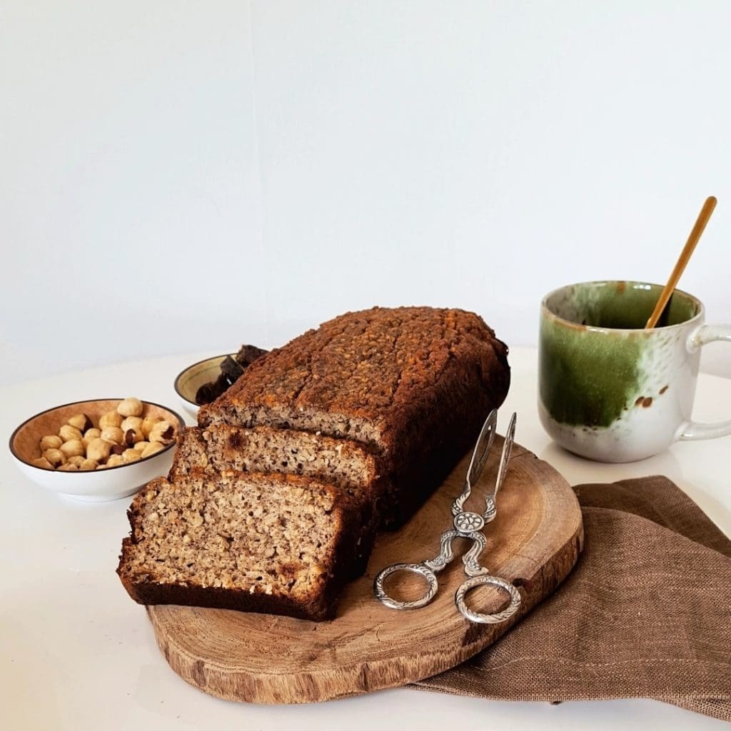 Grekiska flatbreads 10 Skivat bananbröd på en skärbräda med en kopp och nötter i bakgrunden.