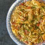 En tallrik med krämig räkpasta bestående av tagliatelle, räkor och tomater.