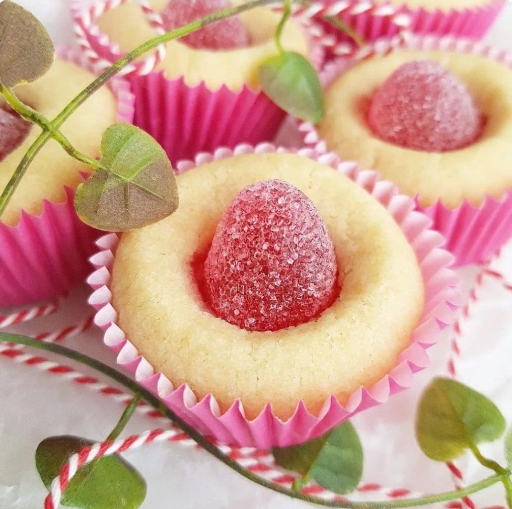 Chokladbollar utan tillsatt socker 7 Bakverk med rosa formar och sockerbelagd hallongodis i mitten.