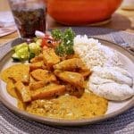 En tallrik med korv stroganoff, ris, grönsaker och sås, serverad med dill.