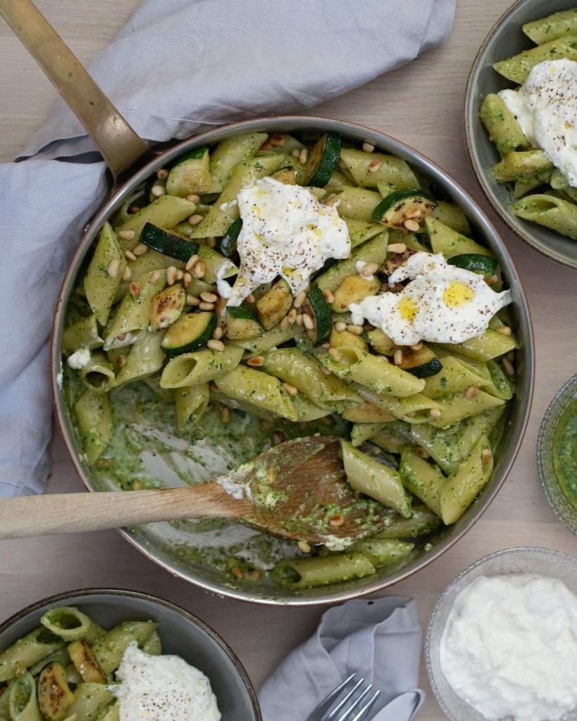 Salsicciapasta med vitlök och citron 13 En skål med pasta, pesto, zucchini och toppad med burrata och pinjenötter.