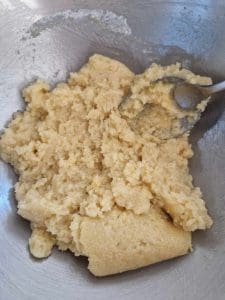 En skål med blandning av smet för hallonkaka, med en sked lutad mot kanten.