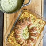 Ugnsgratinerad falukorv i en glasform med potatismos i en kastrull bredvid.