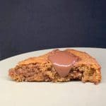 En bit kaka med chokladfyllning på en tallrik, delvis skuren för att visa insidan.