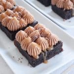 Brownies med chokladkräm och kolasås på en vit tallrik.