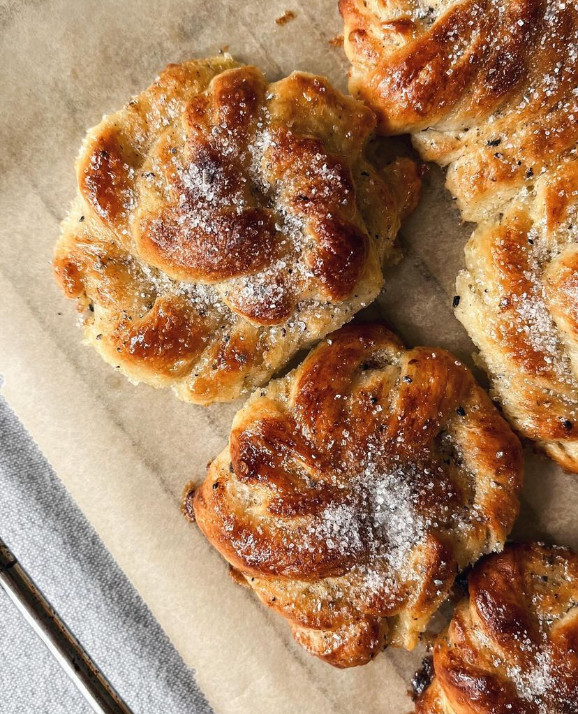 Donuts 10 Fyra kanelbullar med socker på toppen, placerade på ett bakplåtspapper.