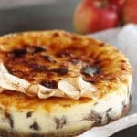 Karamelliserad äpplecheesecake med en gyllene yta och dekoration av torkade äppelskivor.