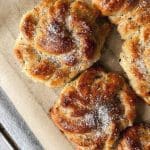 Kardemummabullar med socker på toppen, placerade på bakplåtspapper.