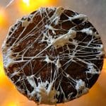 En kladdkaka med vit glasyr som har trådar av glasyr över ytan.