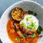 En skål med stroganoff med chorizo, ris och grönsaker, garnerad med mynta och sesamfrön.