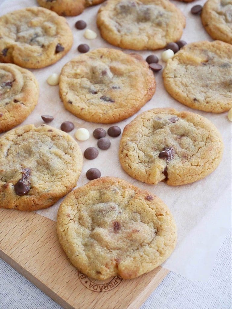 Halloncookies 13 Tre olika sorters chokladchip-kakor på en träplatta med chokladbitar runtomkring.