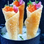 Tre wontonstrutar med fyllning av fiskrom och lök, placerade i en svart skål med is.