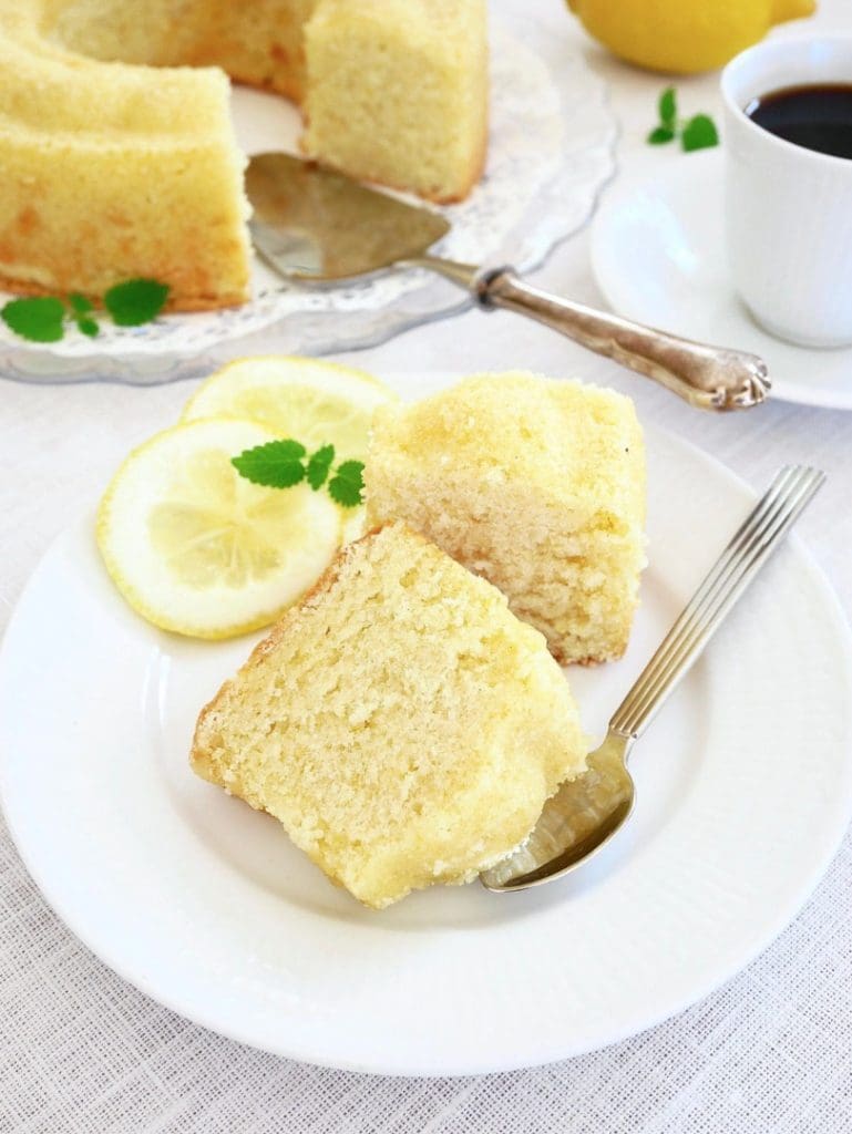 Citronpaj med mördegsbotten 10 Två bitar citronsockerkaka på en vit tallrik med citronskivor och en sked.