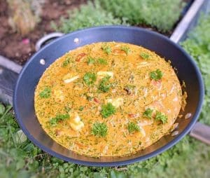 En stekpanna med halloumi stroganoff, dekorerad med färsk persilja och gräslök.