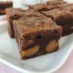 En bit brownie med karamellfyllning på en vit tallrik.