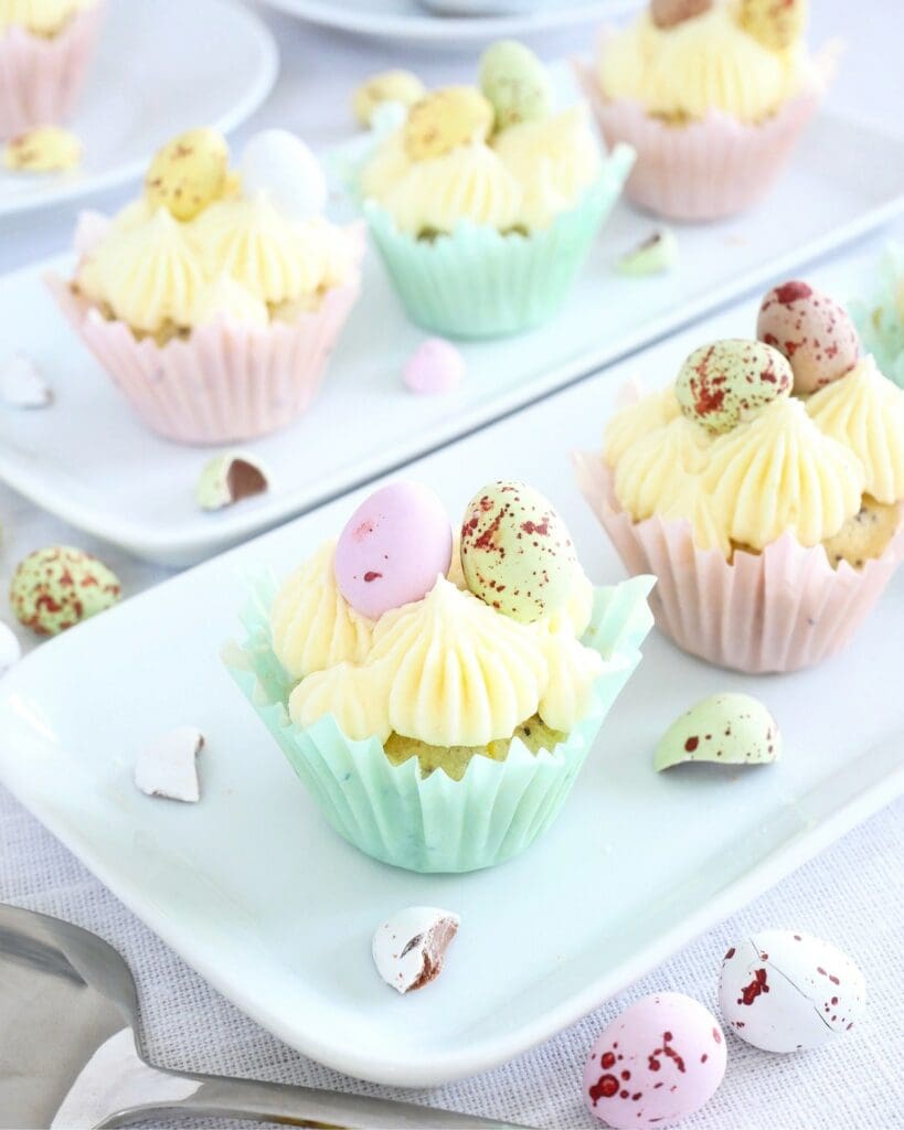 Påskmuffins 7 Cupcakes med gräddfrosting och färgglada påskägg i pastellfärgade formar.