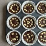 Muffinsformar med kladdkakemuffins dekorerade med Toffifee och vita chokladknappar.