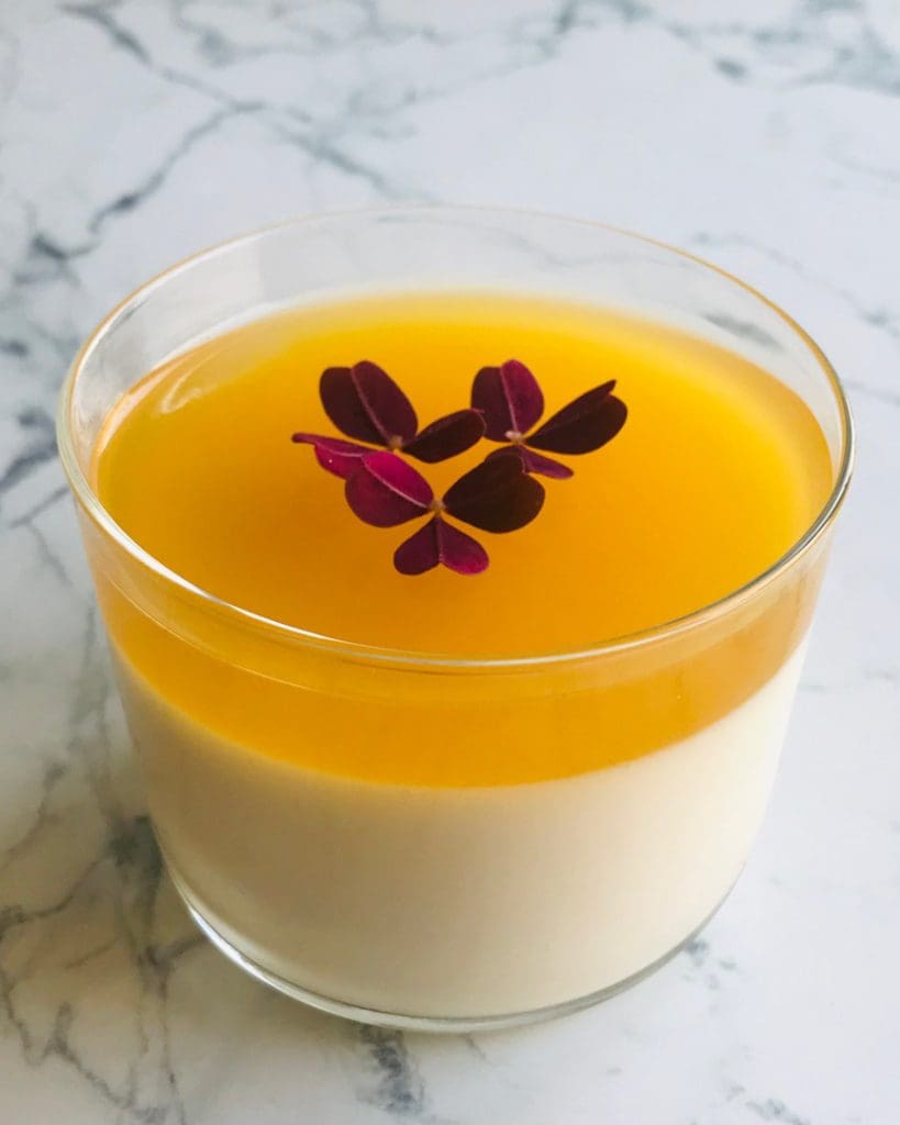 Créme brûlée 8 En skål med pannacotta toppad med passionsfruktsås och ätbara blommor.