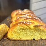 Skivad saffranslängd med sockerpärlor på en träskiva.