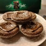 Fem kladdmuffins med After Eight-choklad på toppen, placerade på en vit tallrik.