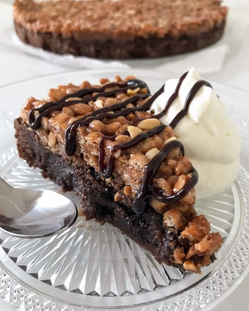 Dammsugarkladdkaka 9 En bit snickerskladdkaka med grädde och chokladsås på en glasskiva.