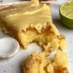 Bit av snovits drömtårta med limefyllning och en limehalva på en tallrik.