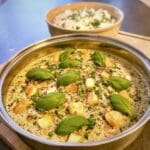 Vegetarisk halloumipanna med vitlök och färsk basilika i en metallpanna.