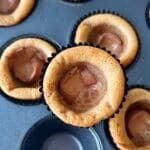 Kaka med chokladfyllning i en muffinsform, med flera andra kakor i bakgrunden.
