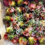 Rostad brysselkål med knaprig bacon och riven parmesan på bakplåt.