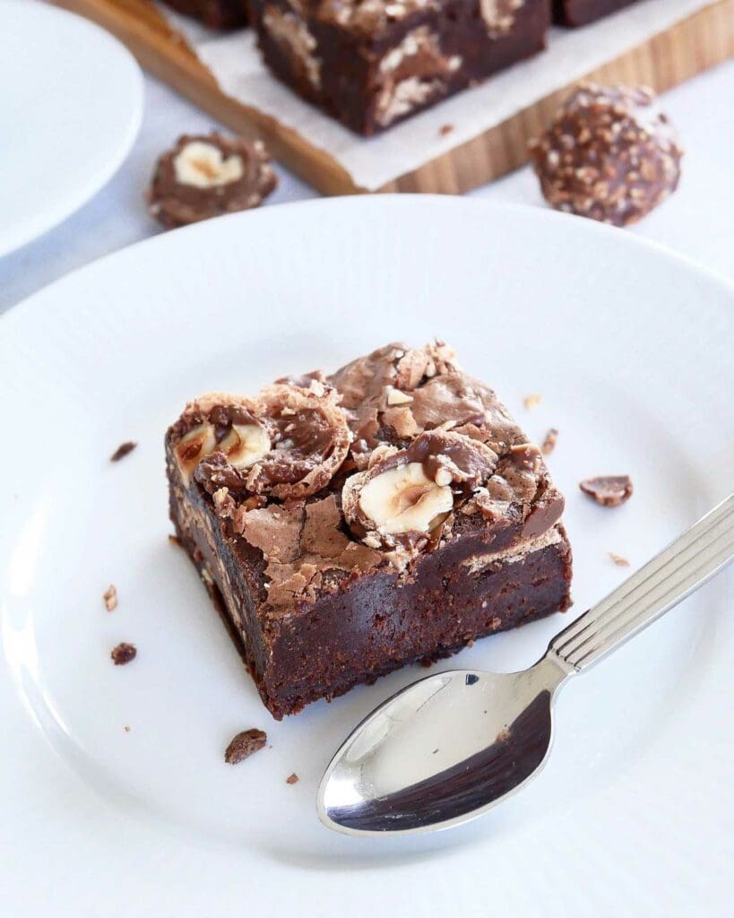 Brownie med mintglasyr 10 En bit Ferrero Rocher brownie med nötter och choklad på en vit tallrik.
