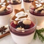 Gloggpannacotta i glas med bärsås, mandlar och pepparkakor på toppen.