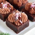 Julbrownies med chokladfrosting och pepparmint på en vit tallrik.