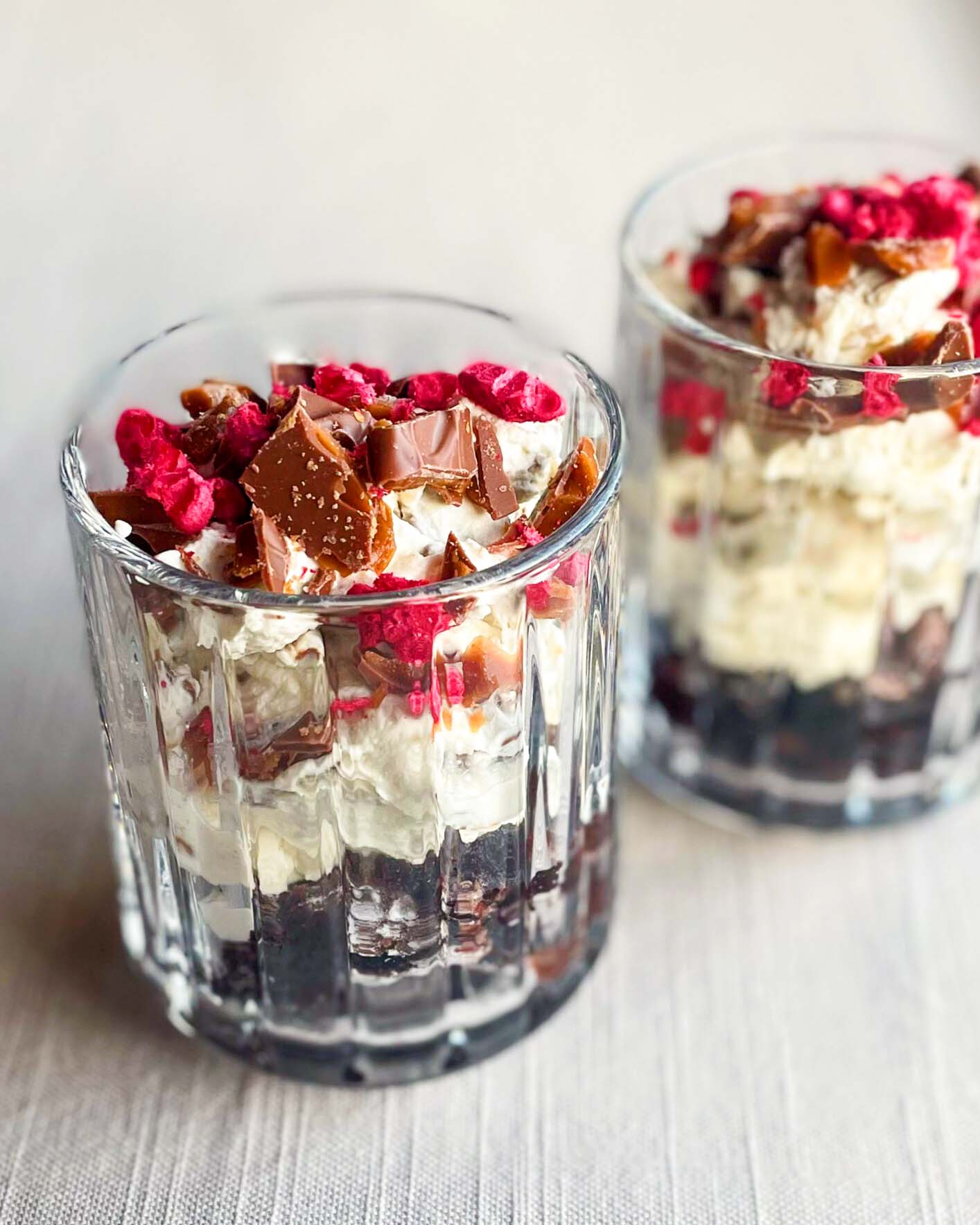 Kladdkakedessert i glas med daimfluff och frystorkade hallon Kladdkakedessert i glas med daimfluff och frystorkade hallon
