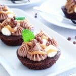 Kladdkakemuffins dekorerade med chokladfrosting, kolasås och mintblad.