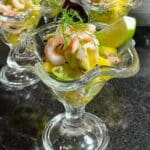 Räksallad serverad i ett glas med avokado, lime och dill på toppen.
