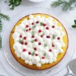 Saffranskladdkaka dekorerad med grädde och röda bär på en glasfat.