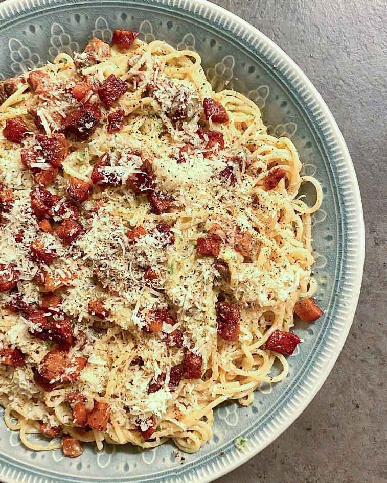 Hannas krämiga salsicciapasta 10 Tallrik med spaghetti carbonara toppad med bacon och riven parmesan.