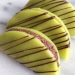 Tre dammsugare tacos med grön marsipan och chokladstrimlor på toppen.