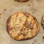 En fusionkaka med chokladbitar och kolasås på en bakplåt.