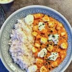 En tallrik med halloumi tikka masala serverad med ris och sås.