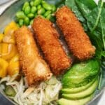 En pokébowl med friterade rullar, mango, edamame, spenat och grönsaker.