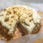 Morotskaka med gräddfrosting och krossade kex på toppen, delad i två delar.